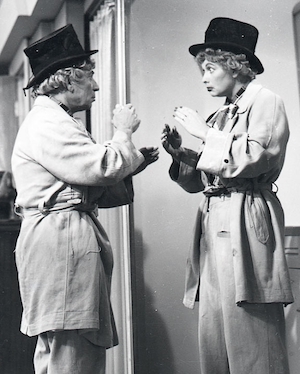 Lucille Ball looking at herself in the mirror--or is it really Harpo Marx?